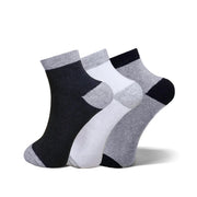 Three pairs of ankle socks in a three-pack, featuring a color-blocked pattern of black, white, and heather gray. The socks are arranged in a fan shape against a clean white background.